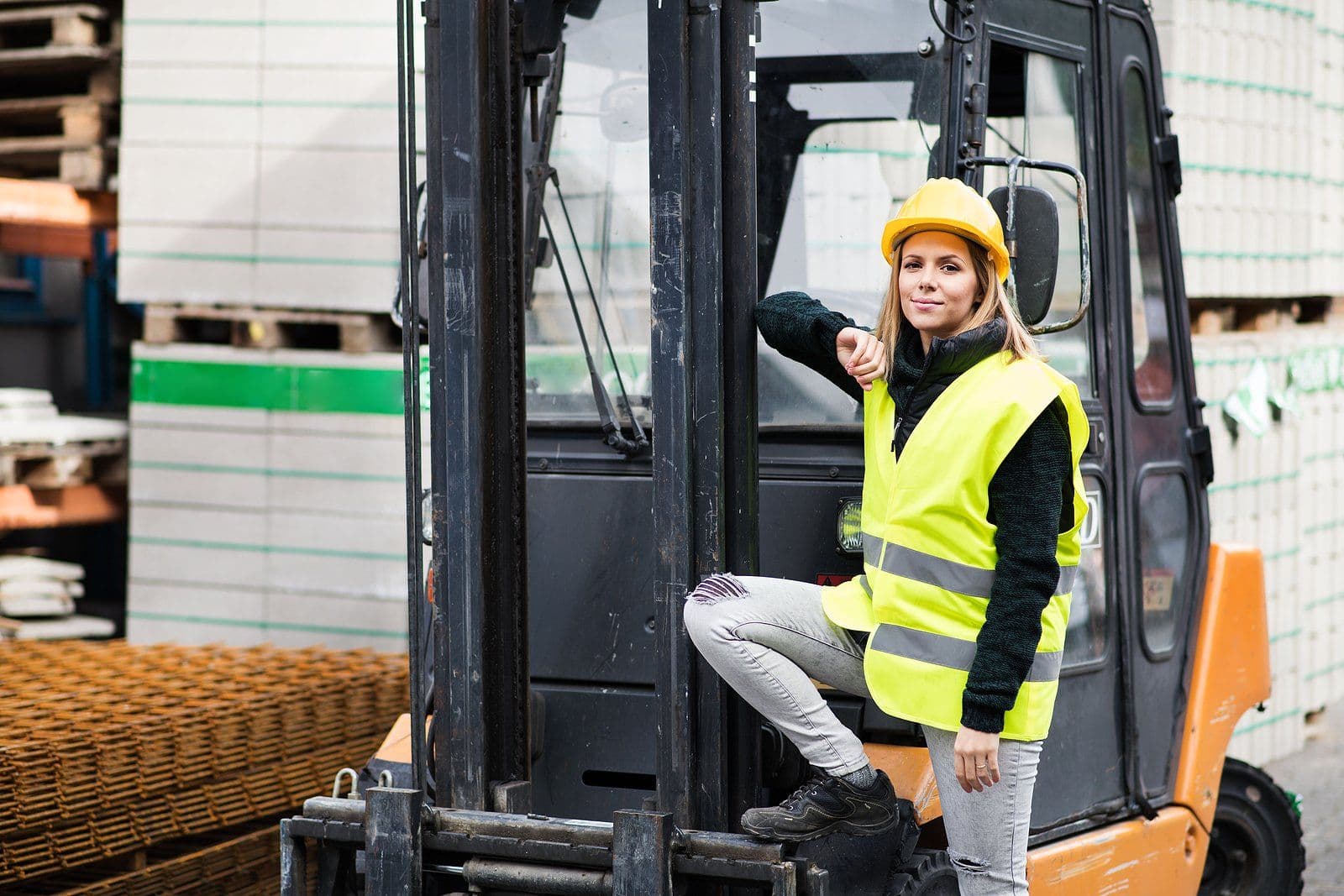 Forklift operator in high-visibility vest in a warehouse